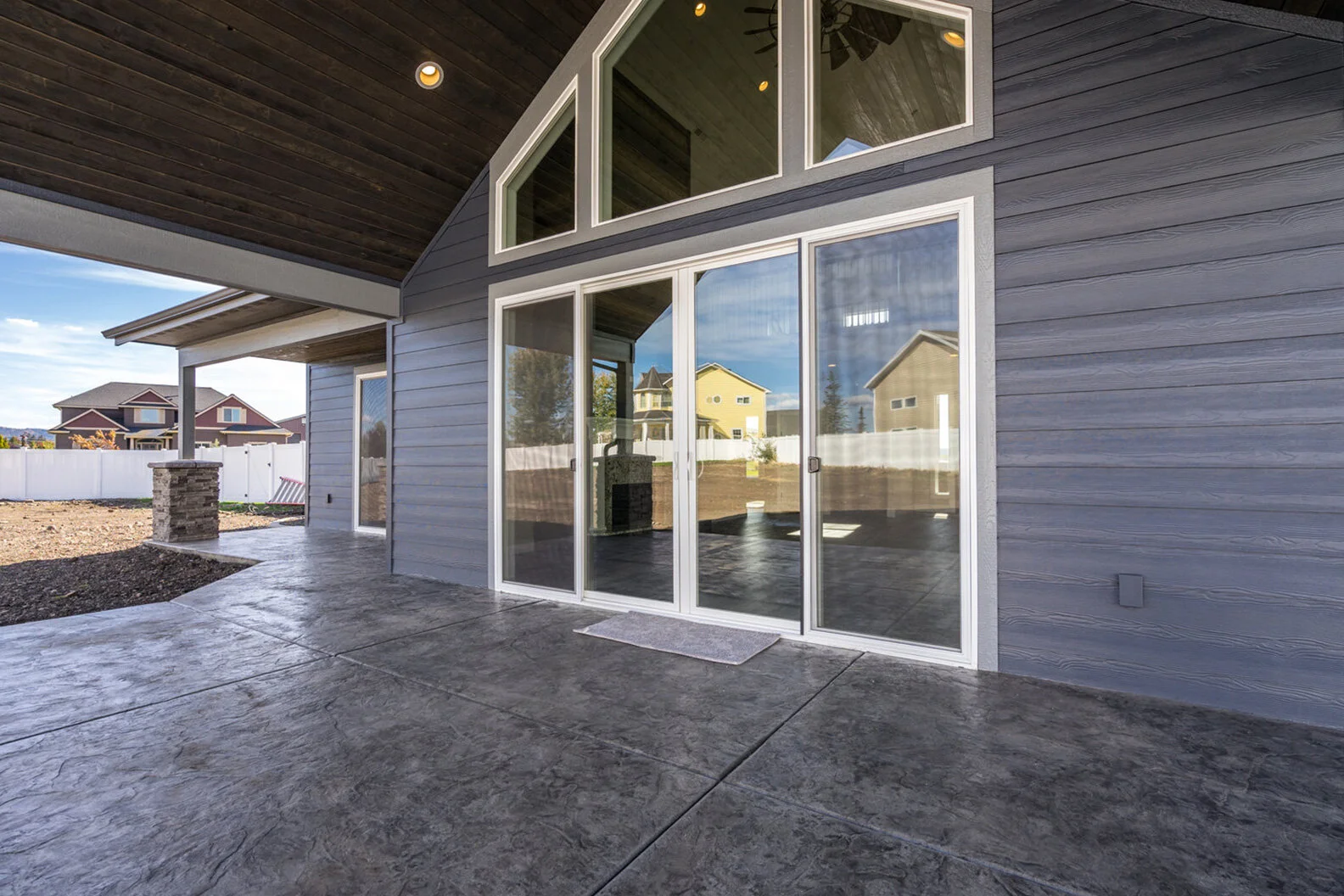 exterior view of covered patio with large glass doors and windows of luxurious custom modern home