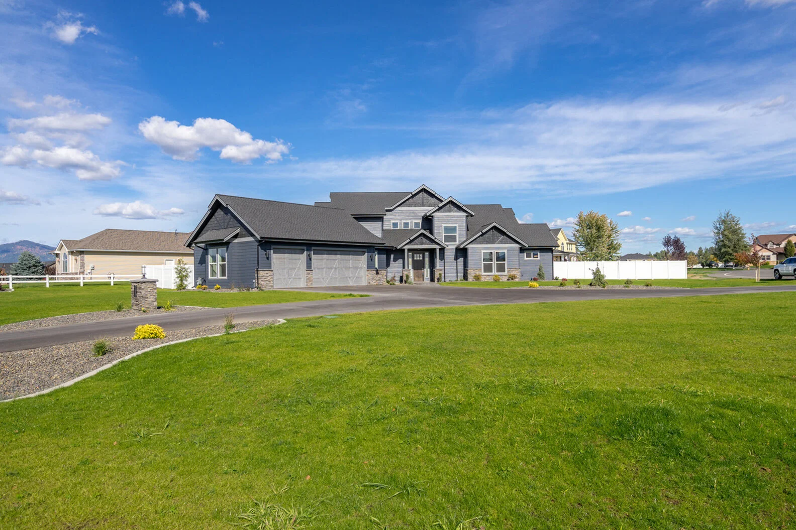 wide view of luxurious custom modern home exterior and large grassy yard